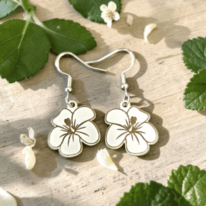 Handcrafted wooden hibiscus dangle earrings with laser-engraved floral line art on silver fishhook ear wires.