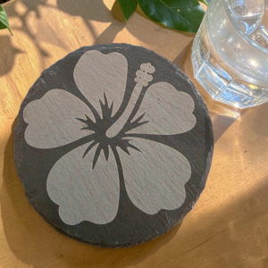 Round hibiscus slate coaster with a detailed laser-engraved tropical flower